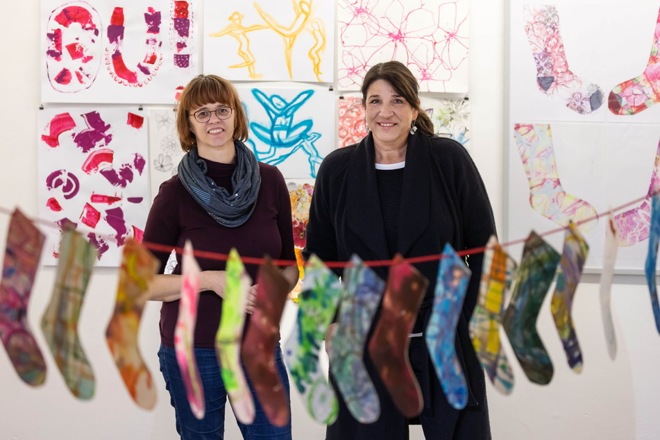 Die Grafikerinnen und Malerinnen Peggy Albrecht (l.) und Anke Kampe inmitten von Werken, die Kinder bei der Sommerakademie des Künstlerbundes gestaltet haben.