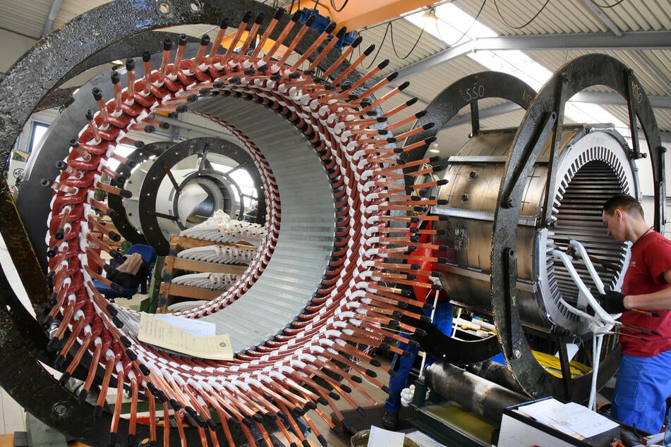 In einem Reparaturwerk arbeitet ein Mitarbeiter an Statoren für Elektromotoren und Generatoren.