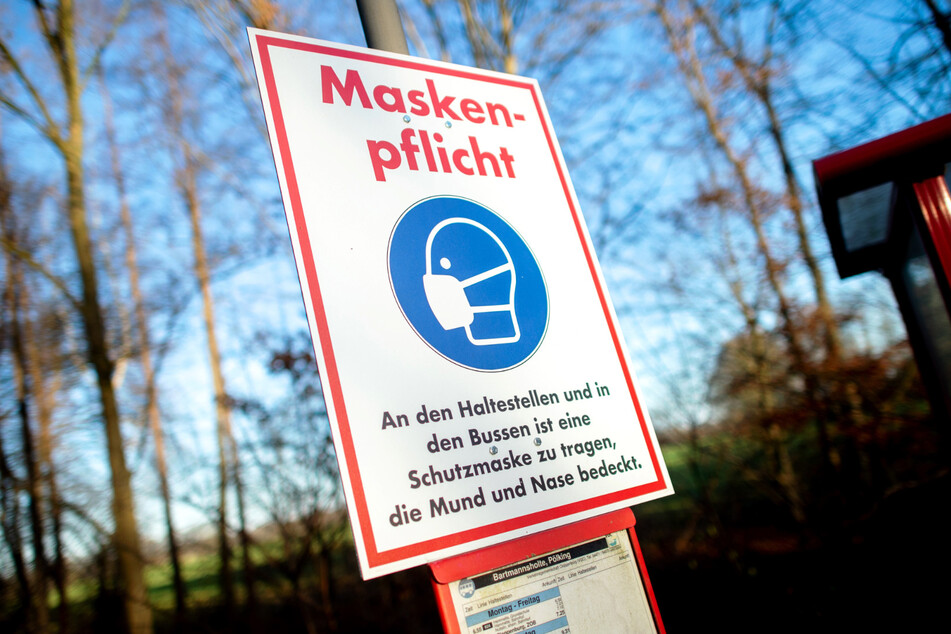 Ein Schild mit der Aufschrift "Maskenpflicht" hängt an einer Bushaltestelle. (Symbolbild)