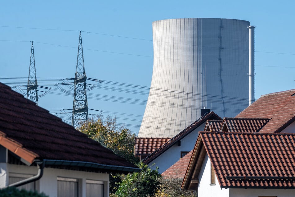 Der Kühlturm des Kernkraftwerks Isar 2 ist hinter Häusern von Niederaichbach zu sehen. Künftig soll hier in Niederbayern radioaktiver Abfall aufbewahrt werden.