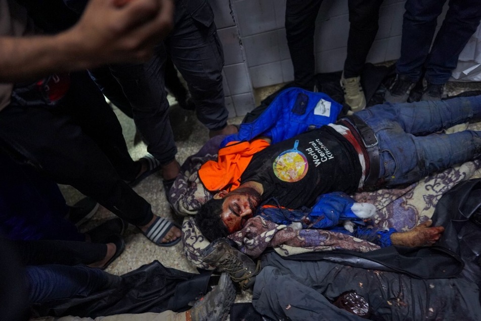 People gather around the body of one of the slaughtered World Central Kitchen aid workers at Al-Aqsa Hospital in Deir al-Balah, Gaza Strip, on April 1, 2024.