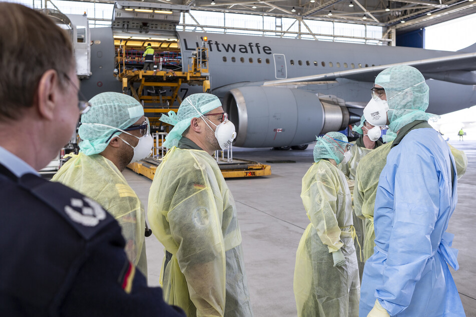 Rettungskräfte stehen auf dem Flughafen Köln/Wahn in einem Hangar vor dem Airbus A310 MedEvac, der fliegenden Intensivstation der Bundeswehr.