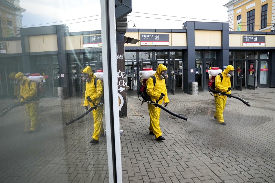 Mitarbeiter des Katastrophenschutzes desinfizieren einen Bahnsteig eines Moskauer Bahnhofs.