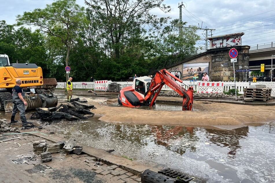 Der Bagger steckt in einer mit Wasser gefüllten Baugrube fest.