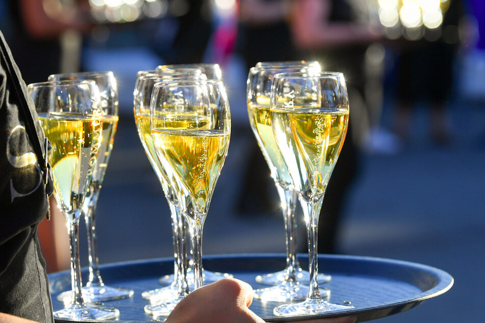 Eine Frau hält Gläser mit Champagner. Weil ein "Champagner Sorbet" nicht nach dem französischen Schaumwein schmeckte, gingen Hersteller gegen die Bezeichnung von Aldi vor. (Symbolbild)