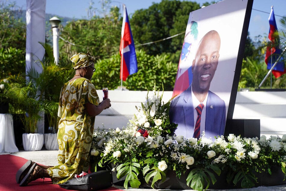 A supporter of Haitian President Jovenel Moise prays at a memorial marking the first anniversary of his assassination, in Port-au-Prince on July 7, 2022