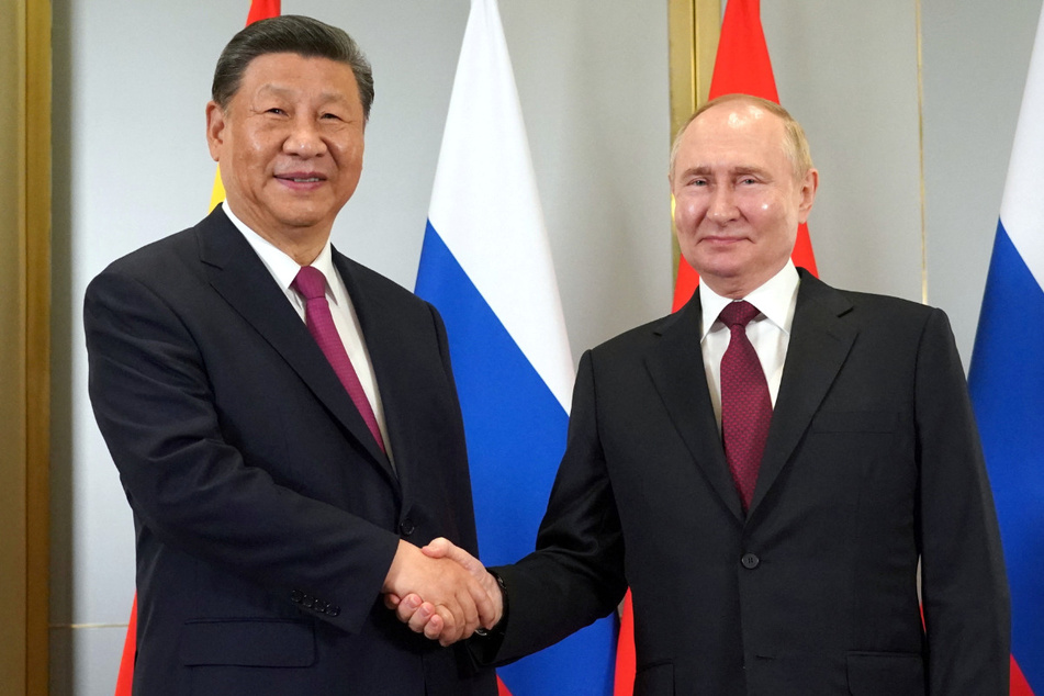 Russian President Vladimir Putin (r.) shakes hands with Chinese President Xi Jinping during a meeting on the sidelines of the Shanghai Cooperation Organization summit in Astana, Kazakhstan.