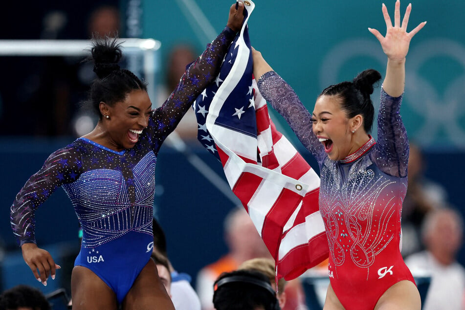 Simone Biles (l.) and Sunisa Lee celebrate winning gold and bronze, respectively, in the women's gymnastics all-around final at the Paris Olympics.