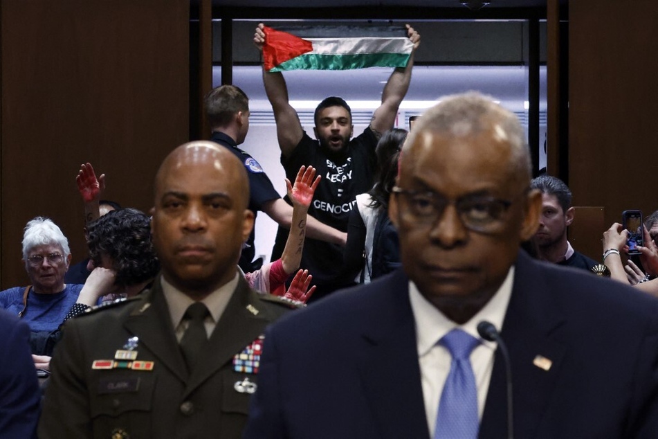 A protester raising a Palestinian flag interrupts Secretary of Defense Lloyd Austin as he testifies before the Senate Armed Services Committee.