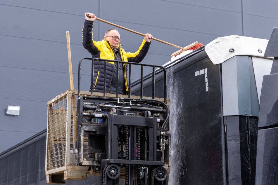 Uwe Kesselboth (55) zeigt das selbst erfundene Lkw-Reinigungssystem mit Gabelstapler und Gitterbox bei der Firma Europa Logistik.