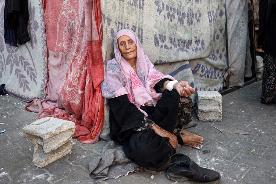 An elderly Palestinian woman sits at a school sheltering displaced people, in Nuseirat in the central Gaza Strip.