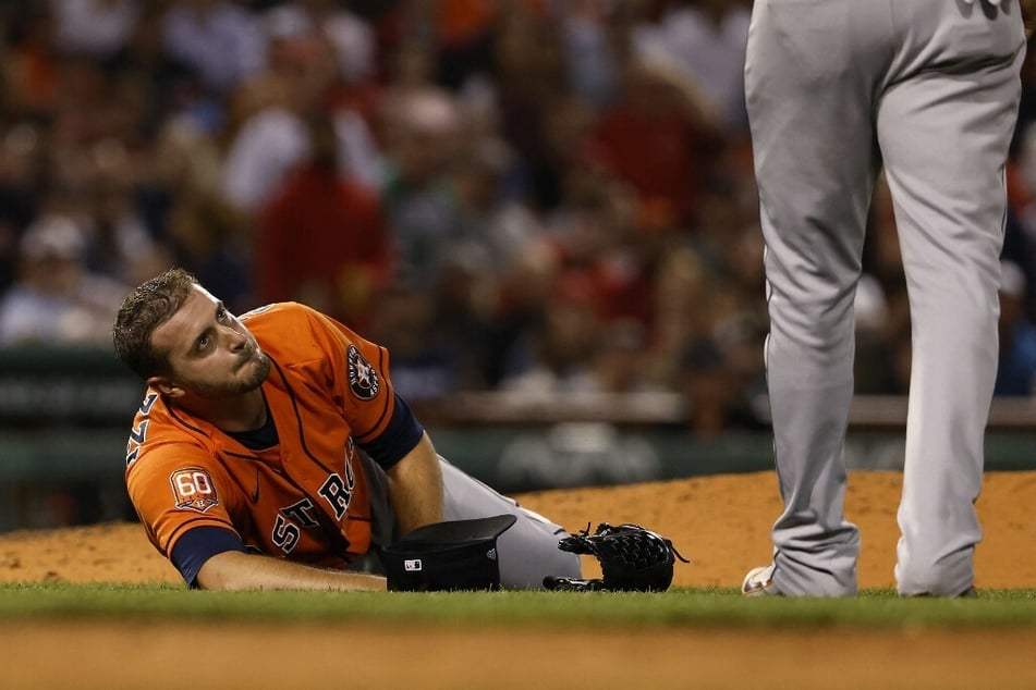 Pitcher Jake Odorizzi of the Houston Astros looked up at a teammate after being injured trying to get off the mound to cover first base on a ground out by Enrique Hernandez of the Boston Red Sox during the sixth inning at Fenway Park on Monday night in Boston.