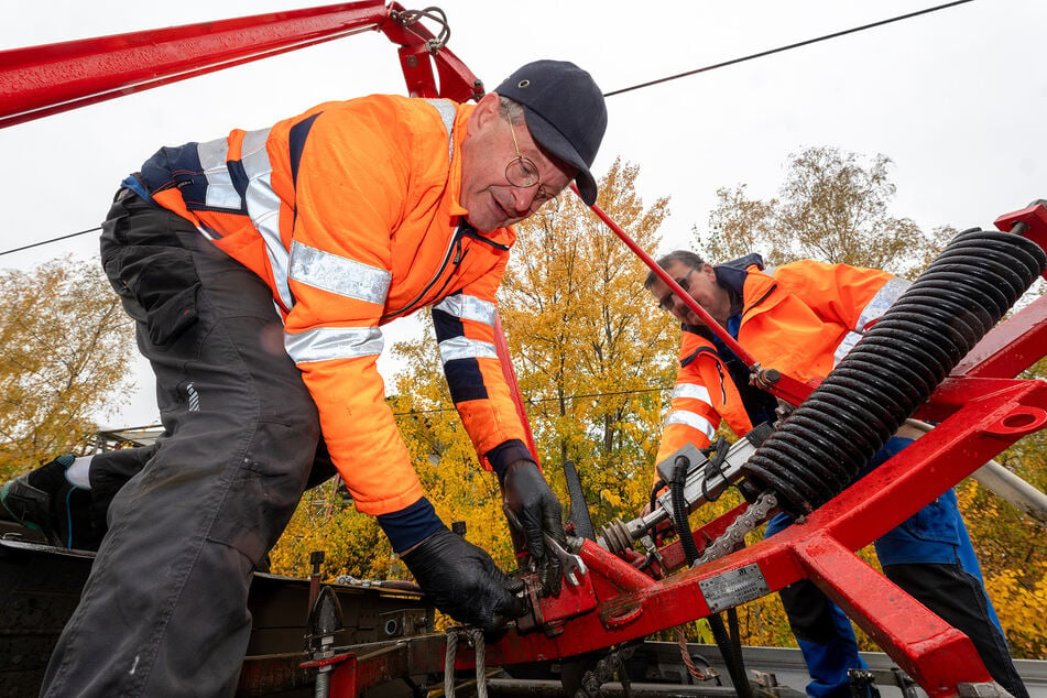 Techniker des Straßenbahnbetriebshofes demontieren den beschädigten Oberleitungsrahmen.