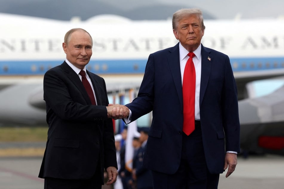 In this pool photograph distributed by the Russian state agency Sputnik, US President Donald Trump and Russian President Vladimir Putin shake hands after their arrival for a US-Russia summit on Ukraine at Joint Base Elmendorf-Richardson in Anchorage, Alaska, on August 15, 2025.