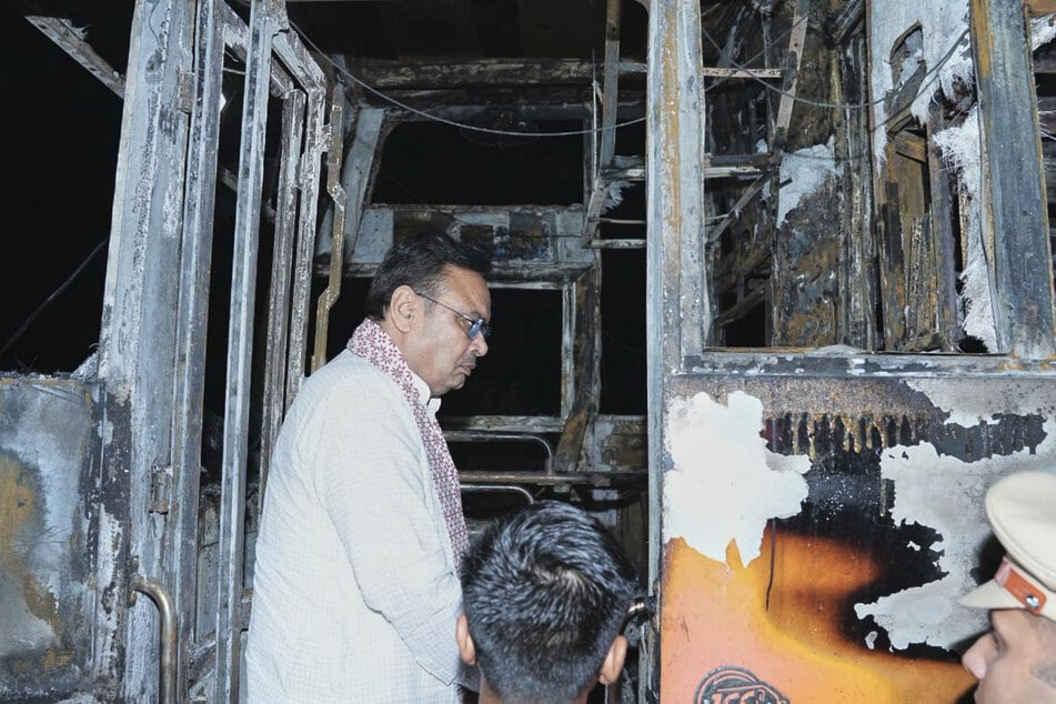 Bhajan Lal Sharma (58), Chef-Minister im indischen Bundesstaats Rajasthan, inspiziert die Überreste des verkohlten Busses.