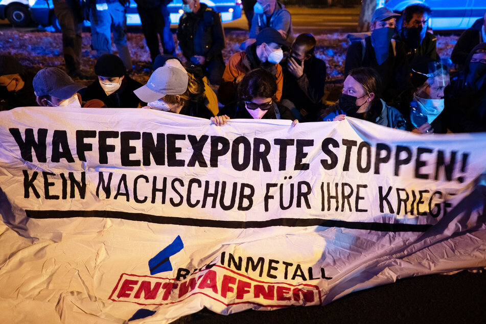 Aktivisten demonstrierten mit einem Plakat "Waffenexporte stoppen!" vor dem Firmengelände des Rüstungsunternehmen Krauss-Maffei Wegmann in Kassel.