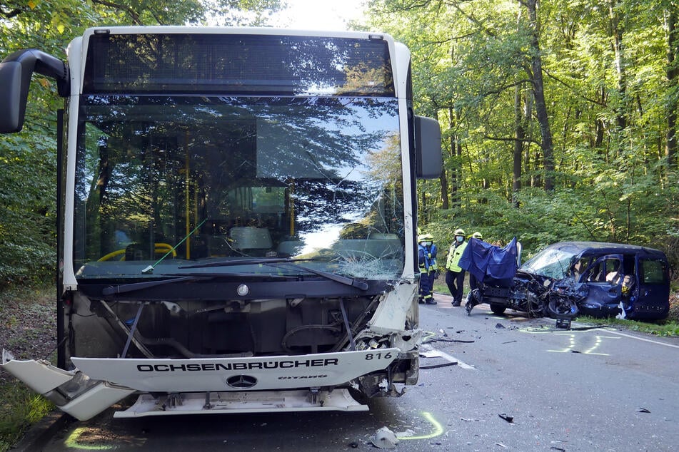 Rettungskräfte stehen neben einem zerstörten Auto. Eine Rentnerin (77) war damit frontal in einen Linienbus gekracht und noch am Unfallort verstorben.