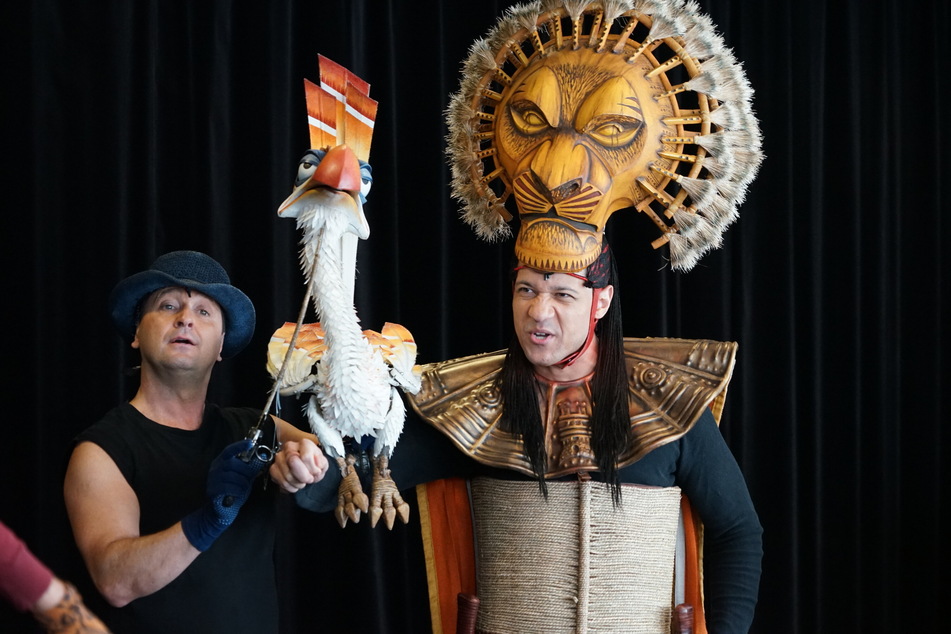 Der Vogel "Zazu" (gespielt von Joachim Benoit, 53) gilt als die am schwierigsten zu spielenden Puppe des Musicals. Die Löwenmasken bedienen die Darstellenden wie hier Mufasa-Darsteller Lamont Alexander Pierce mit speziell einstudierten Kopfbewegungen.