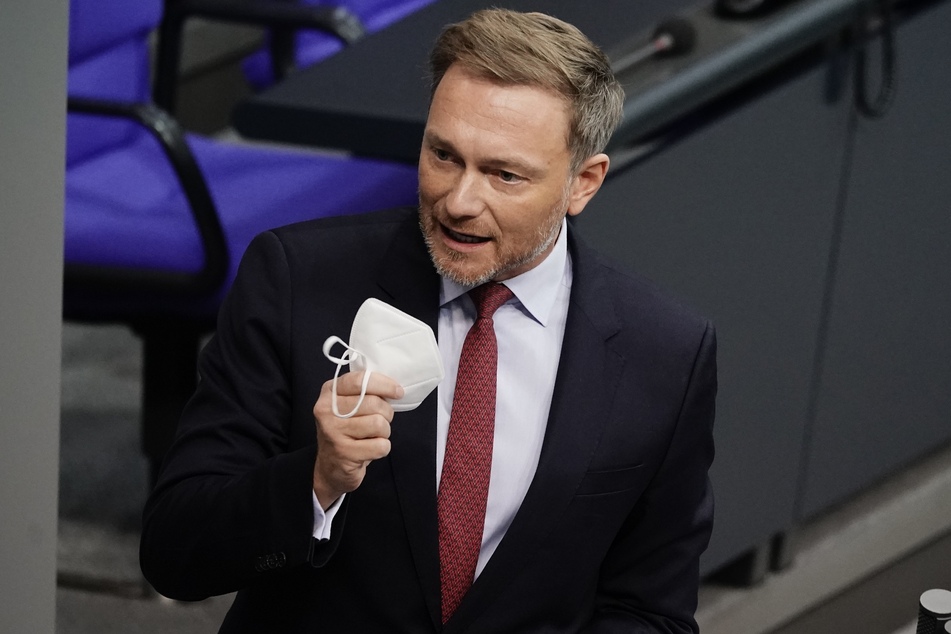 Christian Lindner (42), Fraktionsvorsitzender und Parteivorsitzender der FDP, zeigt seine FFP2 Maske in der Debatte zu Corona-Impfungen im Bundestag.