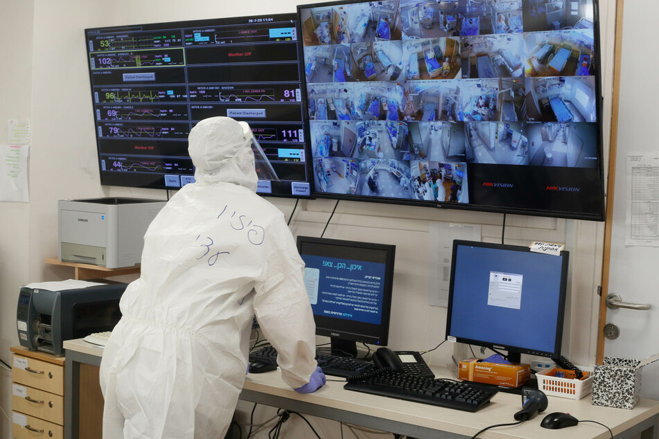 Ein israelischer medizinischer Mitarbeiter beobachtet auf einem Monitor in der Coronavirus-Abteilung des Tel Aviv Sourasky Medical Center (Ichilov) Bilder von den Überwachungskameras in den Patientenzimmern.