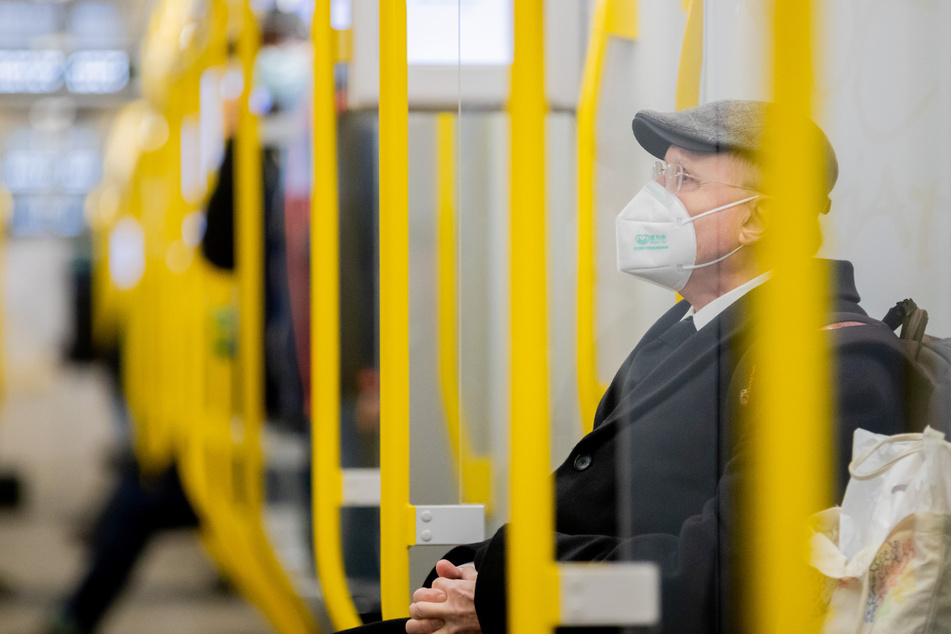 Ein Mann sitzt mit FFP2-Maske in der U-Bahn.