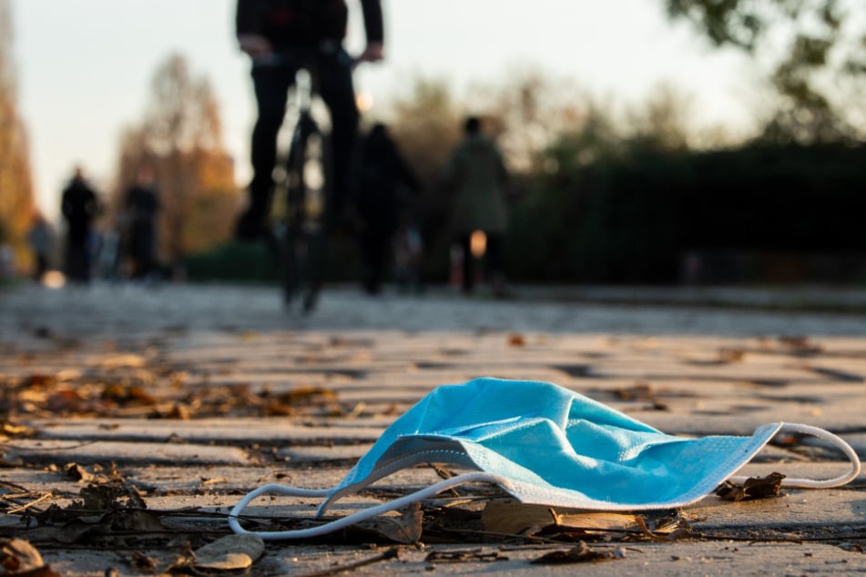 Auf einem Gehweg im Mauerpark Berlin liegt eine Mund-Nasen-Bedeckung auf dem Boden. (Symbolbild)