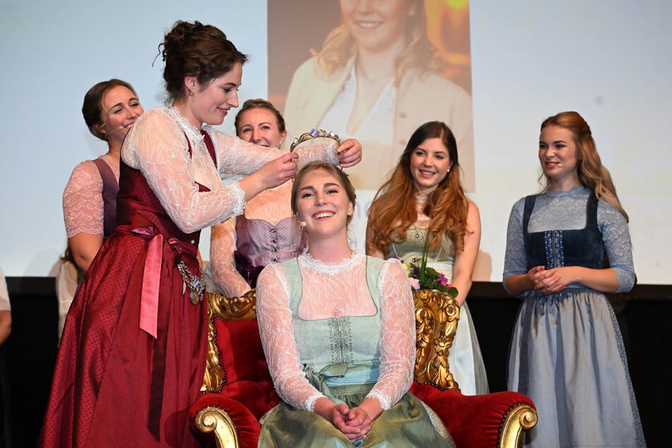 Linnea Klee (M.), wird von der scheidenden Bierkönigin Mona Sommer (l.) im Münchner Löwenbräukeller gekrönt.