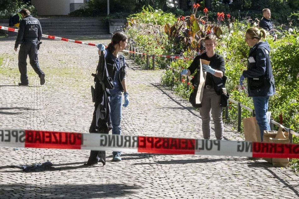 Police officers secure evidence at a crime scene in the Old Botanical Garden.