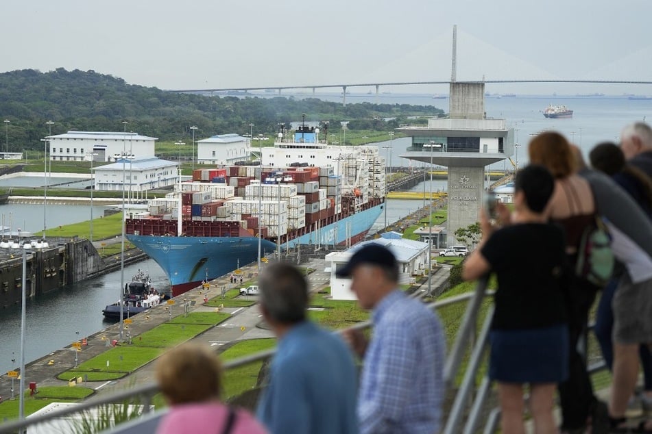 Tourists watch the Danish cargo ship Lars Maersk sailing through the Agua Clara Locks of the Panama Canal in Colon City on December 28, 2024.