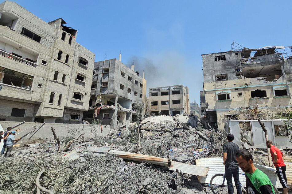 Palestinians inspect a house hit in an Israeli strike in Nuseirat refugee camp, in the central Gaza Strip.