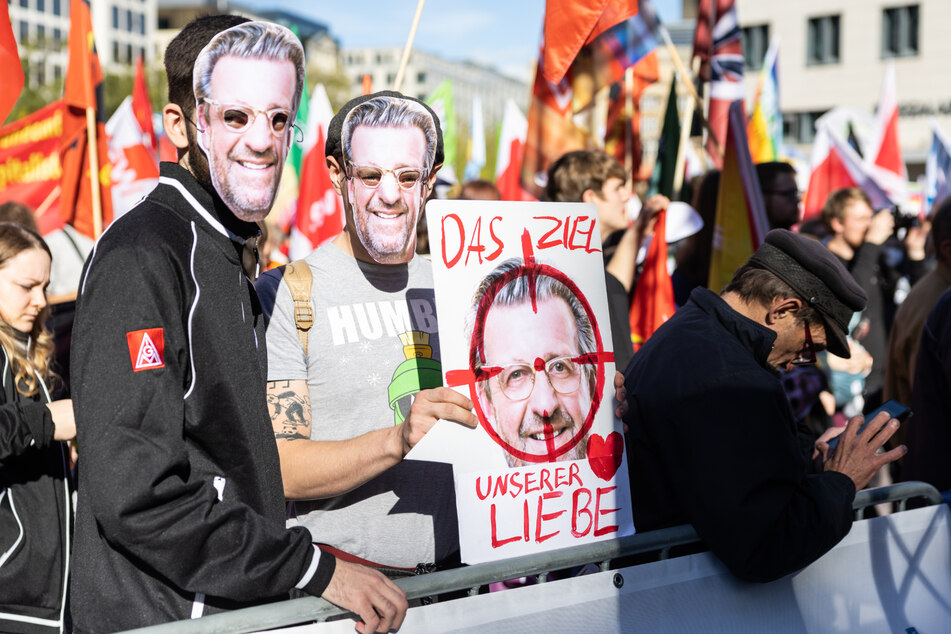 Teilnehmer der Demonstration trugen unter anderem Masken mit dem Gesicht von Stefan Wolf, Präsident des Arbeitgeberverbandes Gesamtmetall, und ein Schild mit der Aufschrift "Das Ziel unserer Liebe".