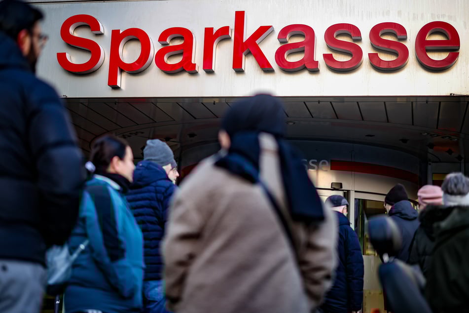 Zahlreiche Menschen, darunter viele Betroffene, standen nur wenige Stunden nach der Tat vor der Sparkasse und warteten auf Informationen der Polizei.