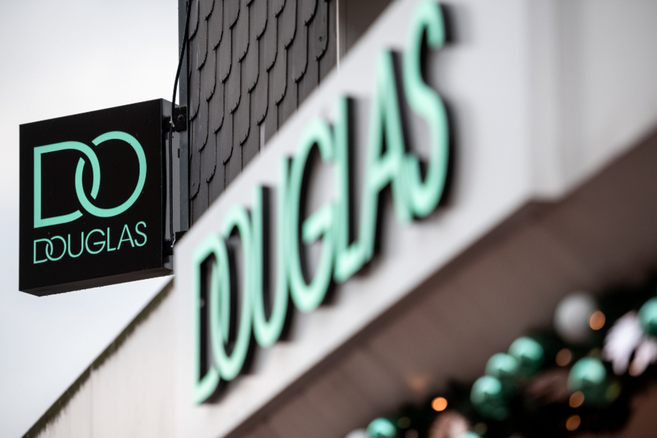 Der Schriftzug mit dem aktuellen Logo der Firma Douglas hängt an einer Außenwand.