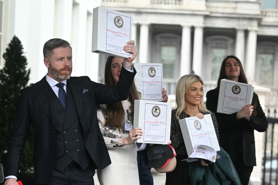 (From L) Political commentator Rogan O'Handley, aka DC Draino, TikToker Chaya Raichik, commentator Liz Wheeler, and conservative activist Scott Presler carry binders bearing the seal of the US Justice Department reading "The Epstein Files: Phase 1' as they walk out of the West Wing of the White House in Washington, DC, on Thursday.