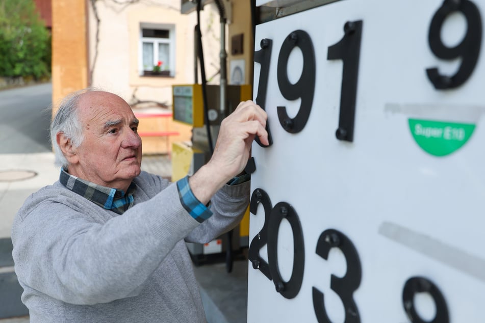 Herbert Brendel bringt an seiner Tankstelle die neuen Preise mit Schrauben an, ohne Digital-Anzeige.