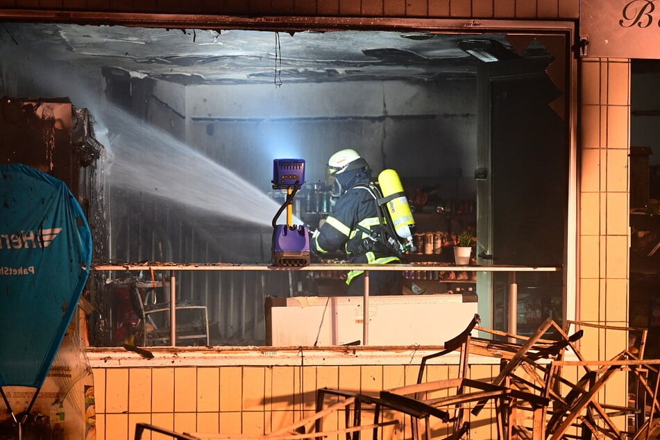 Einsatzkräfte der Feuerwehr Hamburg bei Löscharbeiten im abgebrannten Kiosk.