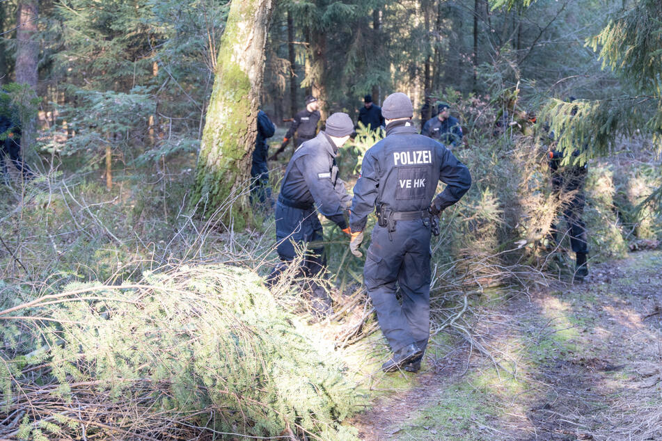 Polizeikräfte befreien den Wald vom Unterholz und suchen nach Beweismitteln.