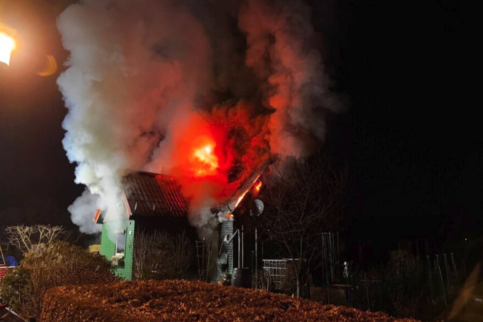 Die brennende Laube ist von dichtem Rauch eingehüllt.