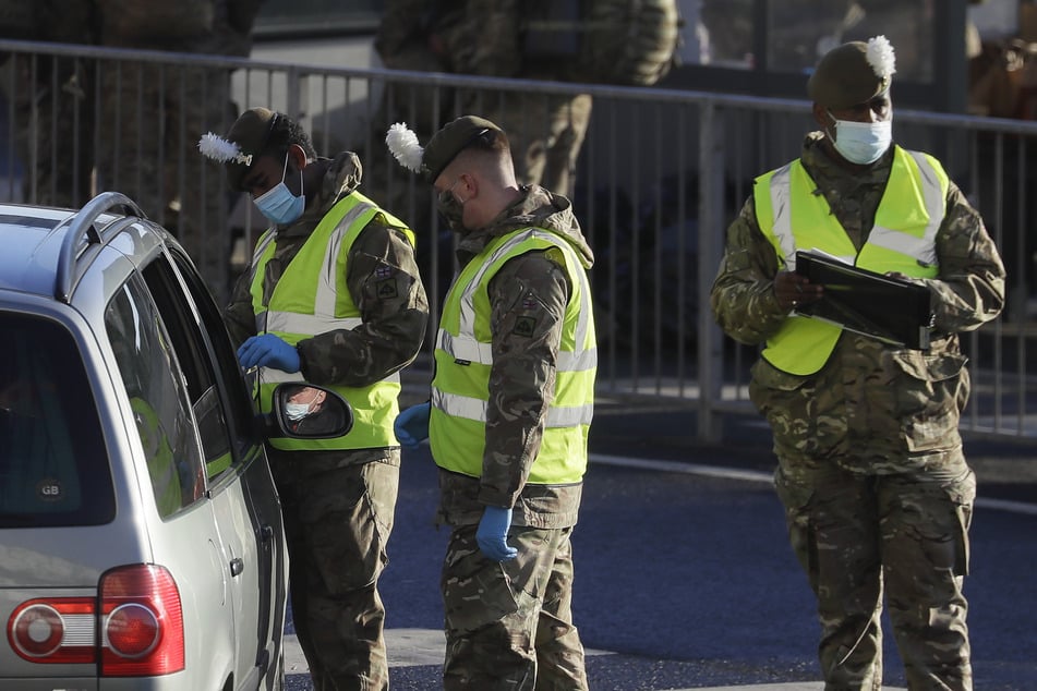 Großbritannien, Dover: Soldaten führen Corona-Test bei einem Autofahrer vor dem Hafen von Dover durch.