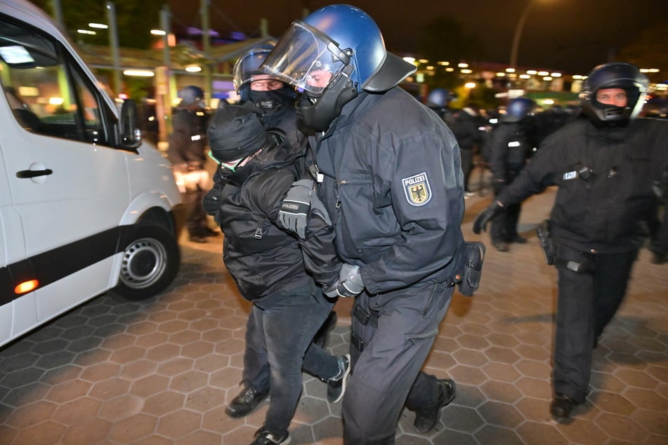 Polizisten nehmen am späten Abend eine Demonstrantin in Gewahrsam.