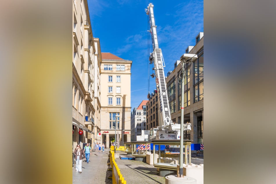 Fußgänger können an der abgesperrten Baustelle vorbeilaufen. Zum Schutz der historischen Vitrinen dienen Betonsteine.