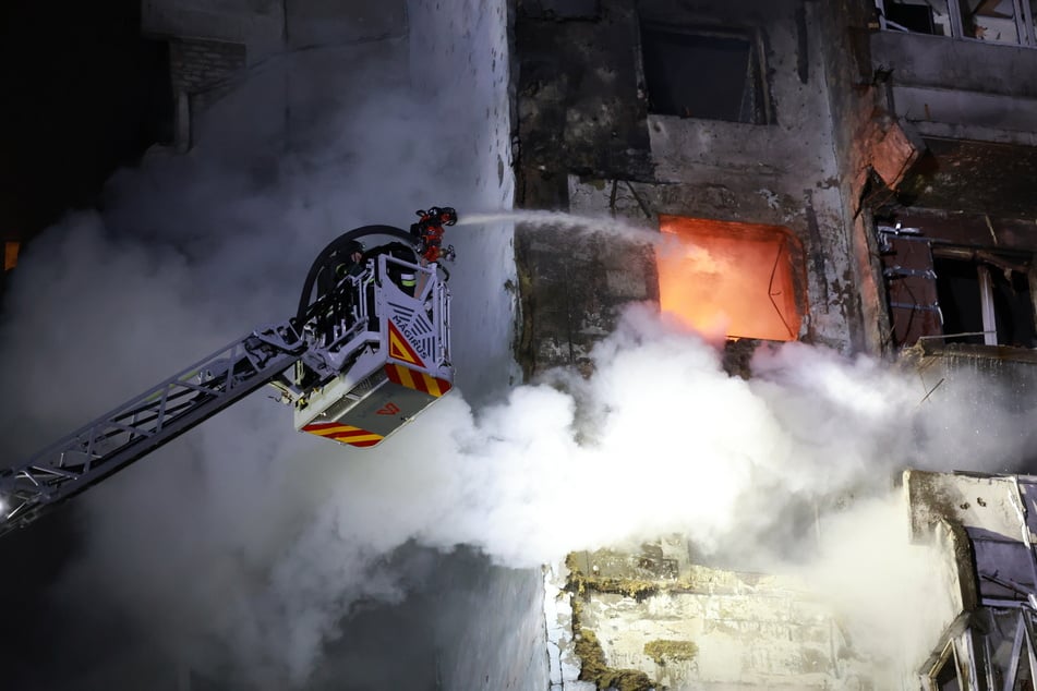 Rettungskräfte versuchen, ein Feuer in einem Wohnhaus n Saporischschja zu löschen, das nach einem russischen Drohnenangriff brennt.