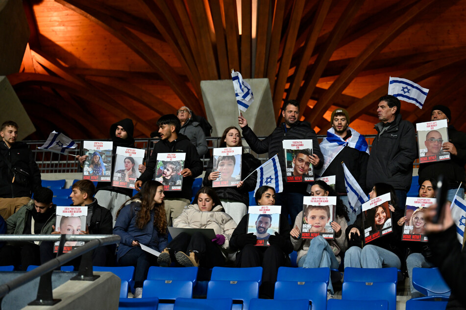 Israelische Fans halten vor dem EM-Qualifikationsspiel gegen die Schweiz Bilder von Menschen hoch, die von der Hamas entführt wurden.