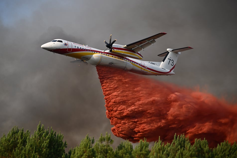 Eine De Havilland Canada Dash 8-400 versprühte Löschmittel über einen in Flammen stehenden Wald im Süden Frankreichs.