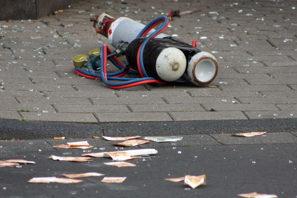Geldscheine und Gasflaschen liegen auf der Straße vor der Commerzbank. Die Täter flüchteten.