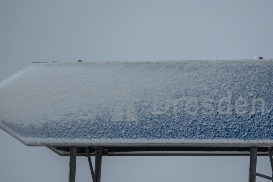 Ein Autobahnschild mit der Aufschrift Dresden an der Autobahn A17 wurde mit Schnee bedeckt. Bis nach Dresden selbst wird der Schnee in den nächsten Tagen allerdings nicht kommen.