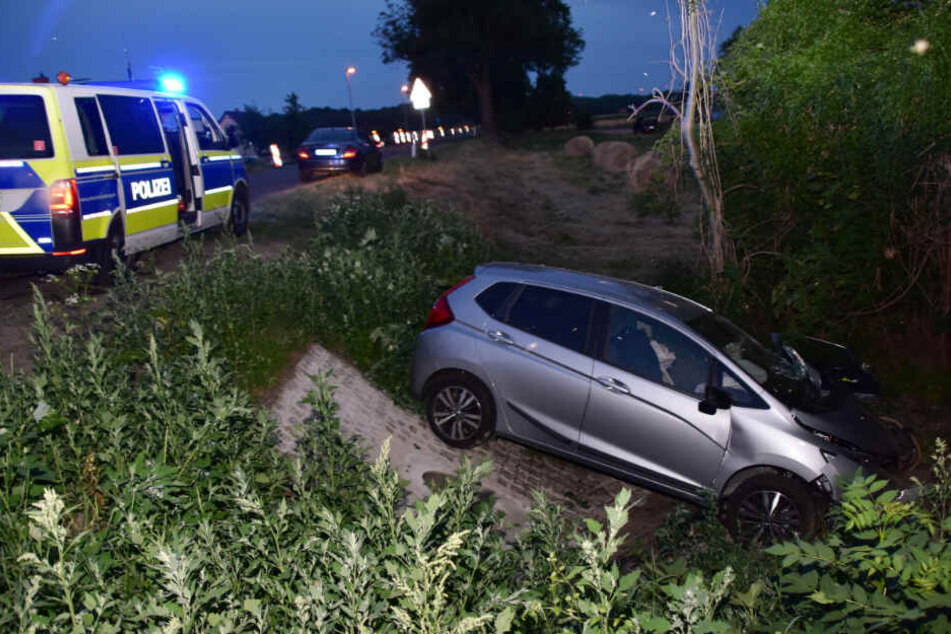 Ein Auto liegt nach einem Unfall im Graben neben der Fahrbahn der Bundesstraße 112.