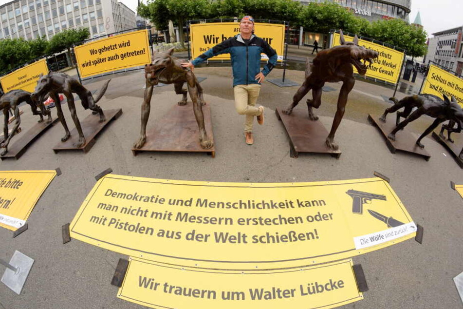 Der Brandenburger Künstler Rainer Opolka steht zwischen seinen Wolfsfiguren auf dem Kasseler Königsplatz.
