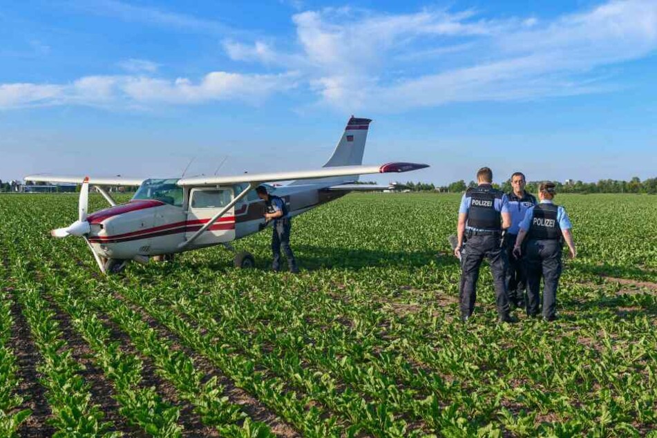 Polizeibeamte untersuchen das Flugzeug kurz nach der Notlandung.