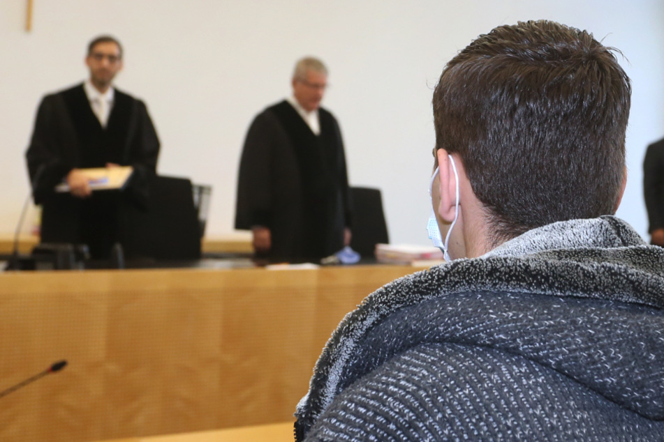 Der Hauptangeklagte steht im Gerichtssaal des Landgerichtes. Drei junge Männer müssen sich vor Gericht in Augsburg verantworten.
